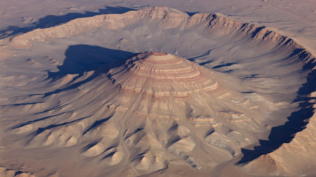 Illustration of a layered mound rising inside a wide crater.